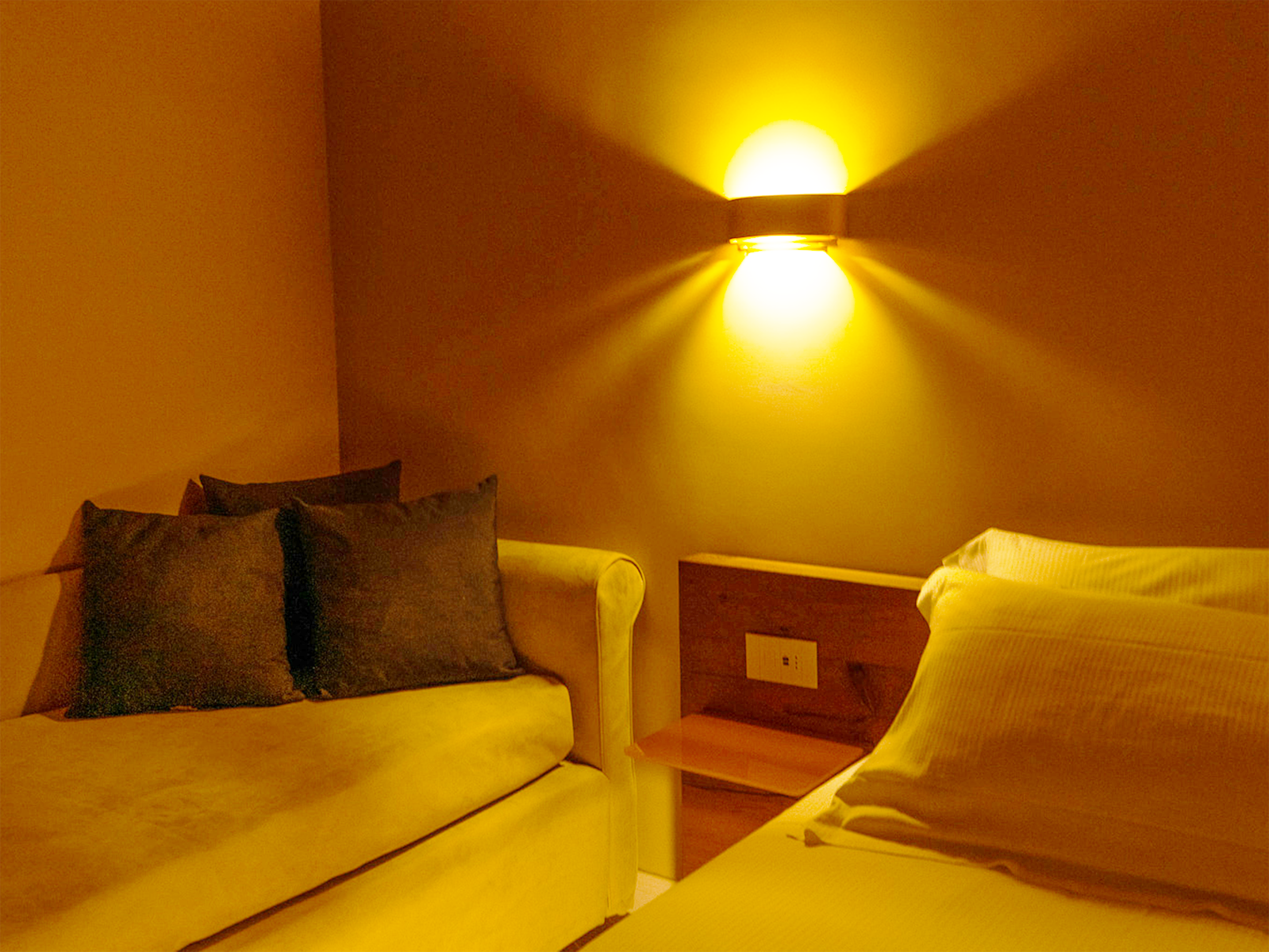 Eleganza Cálida en la Suite GV Cámara con iluminación cálida y mobiliario elegante.