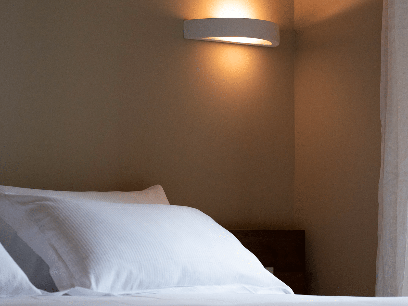 Élégance Sobre dans la Chambre à Coucher Chambre élégante avec lumière tamisée et linge de lit raffiné.