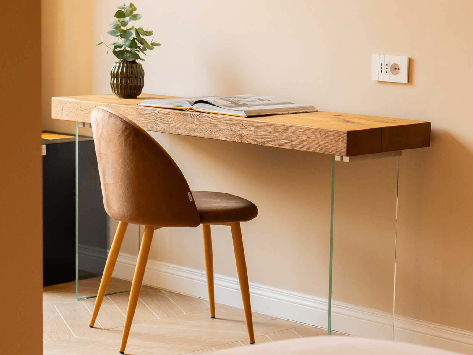 Espace de travail élégant dans une suite de luxe Coin douillet avec un bureau et une chaise en bois, complété par une plante décorative.