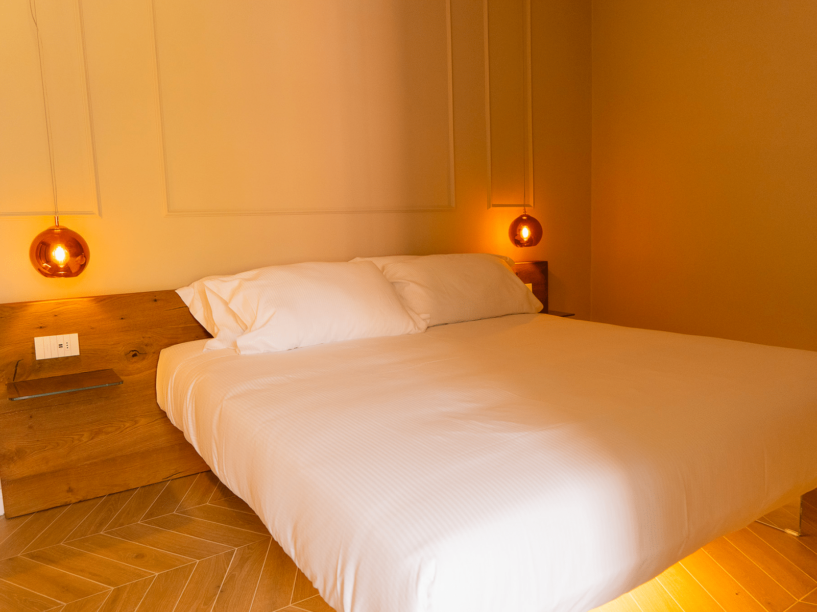 Élégance sobre dans une suite luxueuse Chambre élégante avec éclairage tamisé et mobilier moderne à GV Suite Collection à Rome.