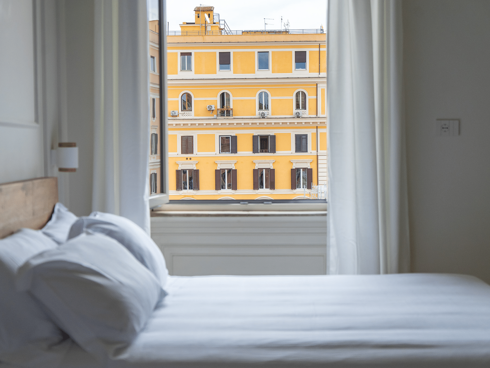 Élégance Romaine avec Vue Historique Chambre à coucher de luxe avec vue sur un bâtiment historique à Rome.