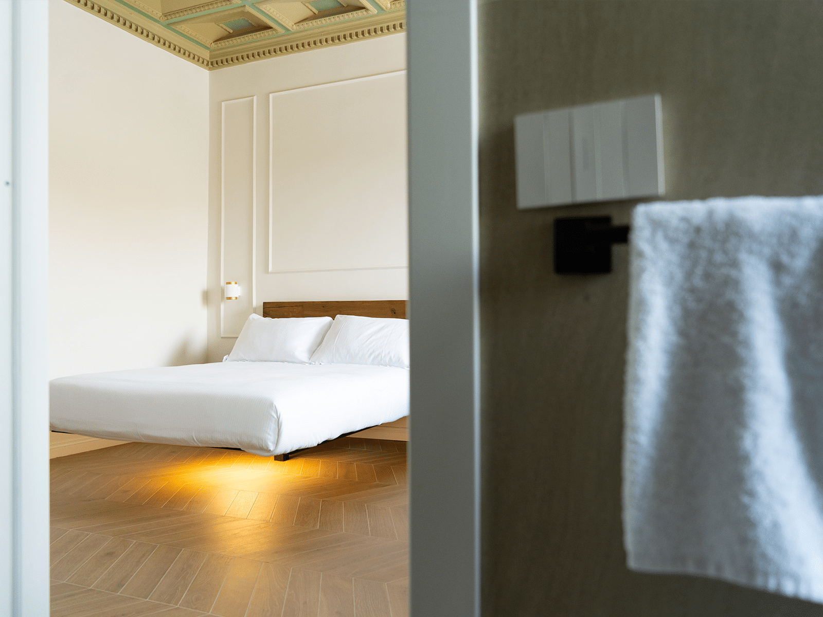 Luxe Moderne et Raffiné à Rome Intérieur d'une chambre élégante avec un lit moderne et un plafond décoré.