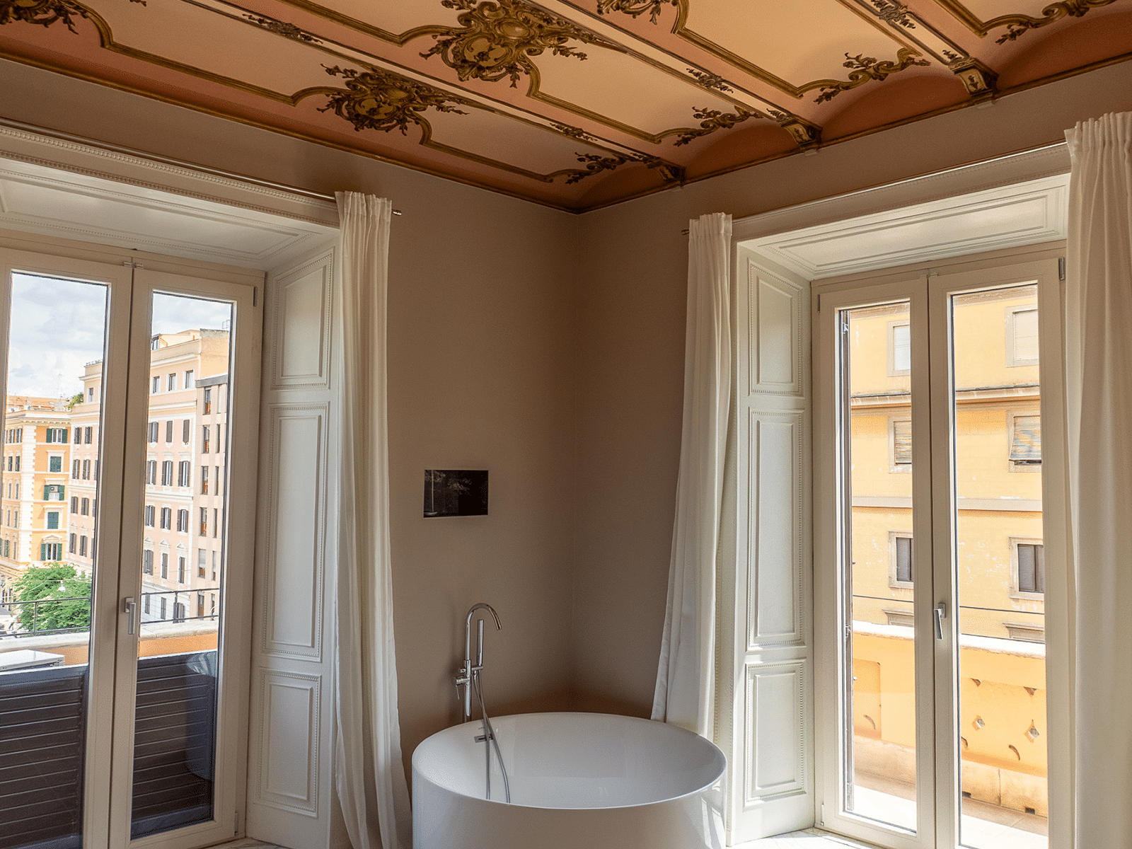 Suite Vue Élégance Romaine Vue depuis une suite élégante avec des éléments de design moderne et un plafond décoré artisanalement.