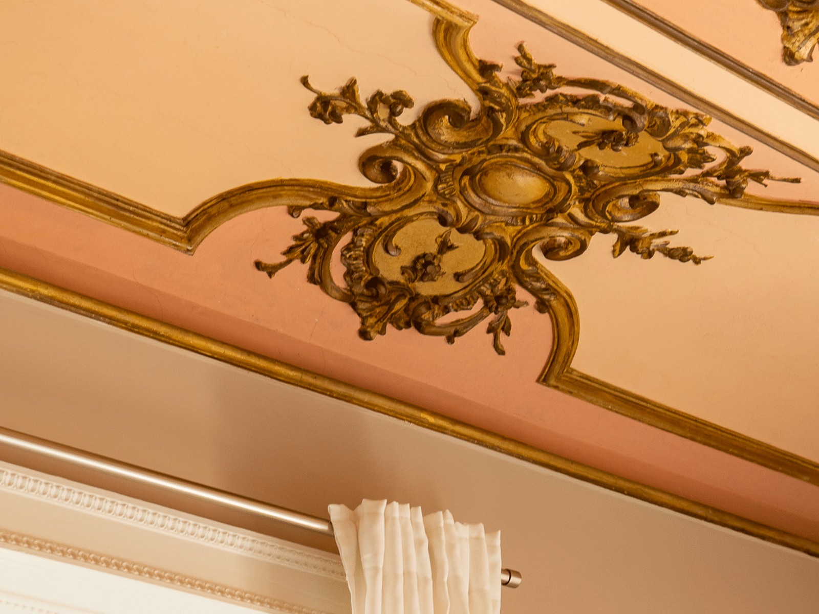 Élégance et Design Innovant Plafond décoré avec des détails dorés et des moulures classiques.