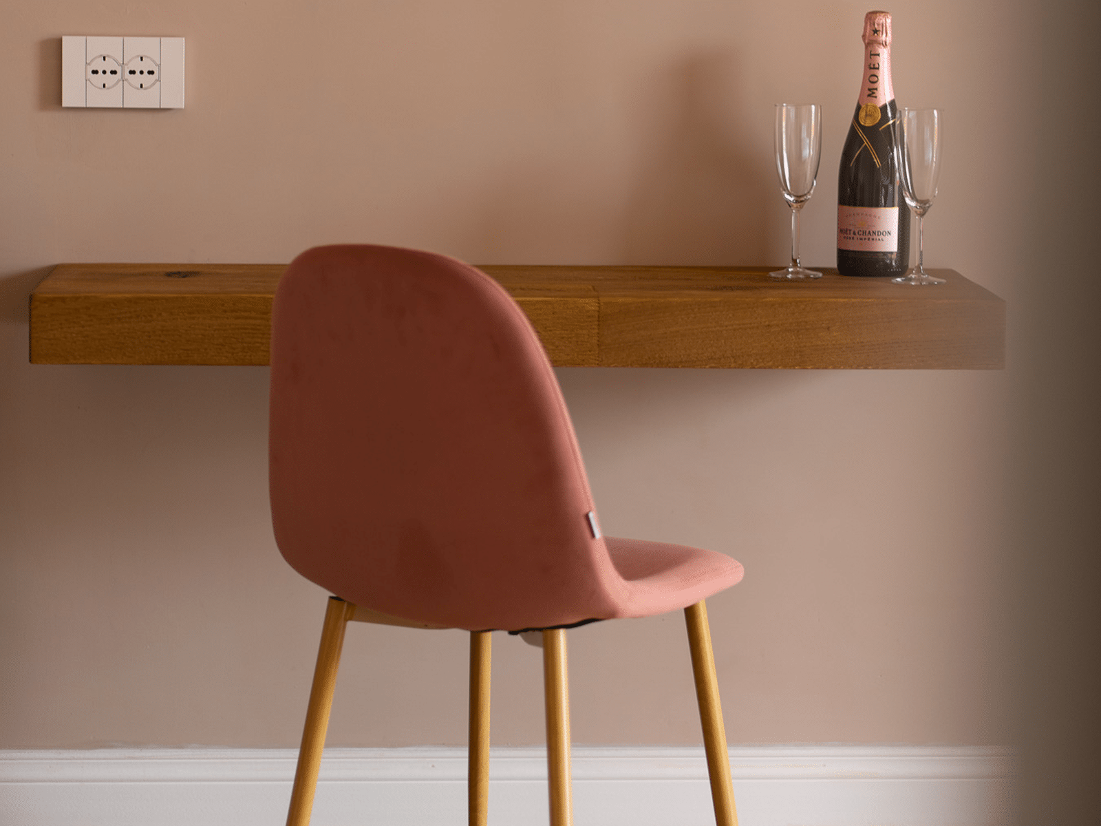 Élégance Suspendue au Cœur de Rome Chaise rose et table avec champagne dans une suite de luxe.