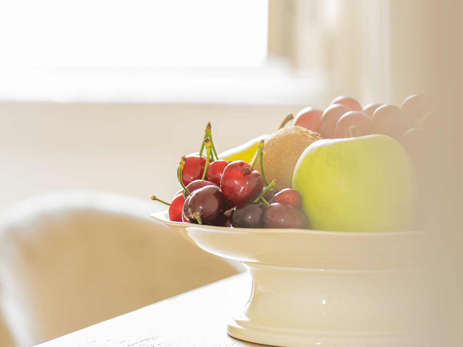 Élégance Simple dans GV Suite Bol de fruits frais sur table raffinée.