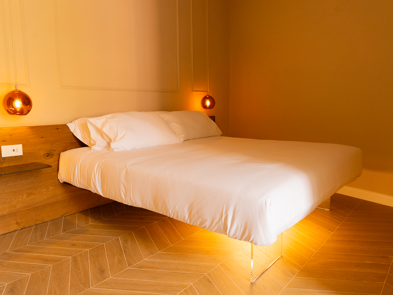 Eleganza Contemporanea nella Camera Suite Camera da letto elegante con luci pendenti e letto matrimoniale.